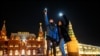 Young people near Moscow's Red Square turn on the flashlights of their cell phones to support jailed opposition politician Aleksei Navalny on February 14, 2021.