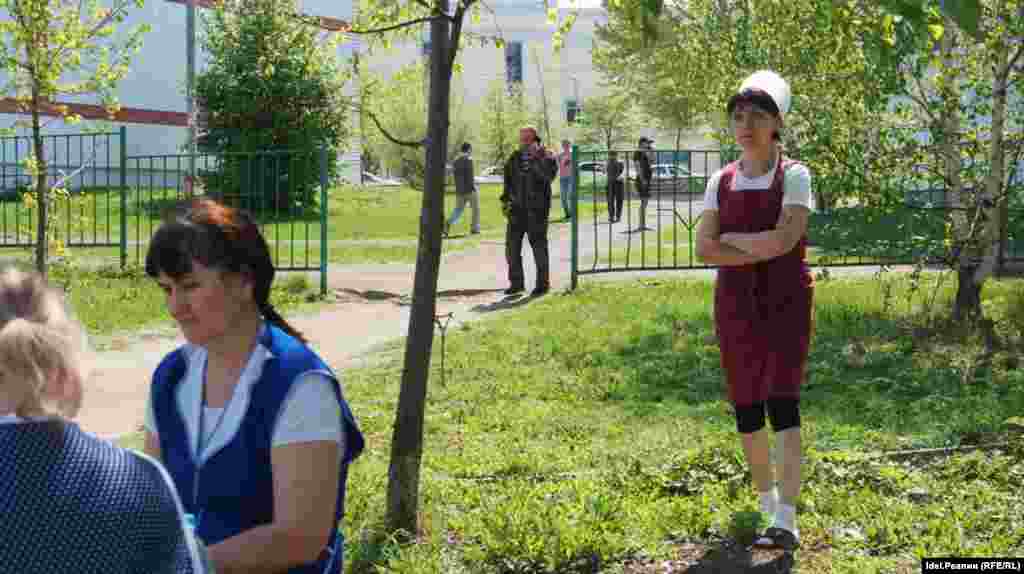 Evacuated employees of School No. 175 look on as law enforcement and emergency personnel work in and around the building on May 11, 2021.&nbsp;