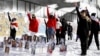 Wearing protesters' symbolic colors of red and white, feminist activists take part in a February 14, 2021 flash mob in Minsk against police violence. On display are photographs of women imprisoned in connection with protests over Belarus' August 9, 2020 presidential elections .